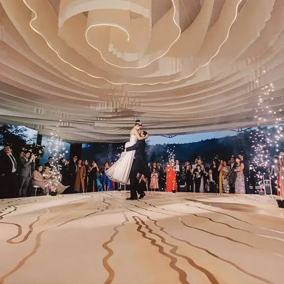 Primer baile de los novios bajo un techo de telas iluminado
